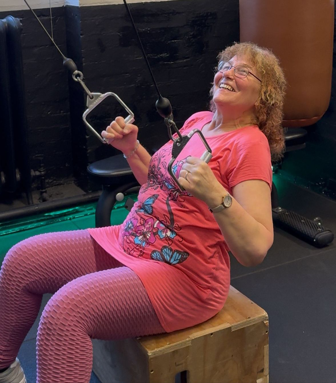Woman laughing during a cable machine exercise at PT Club in Archway, North London