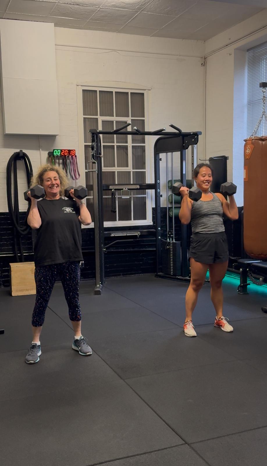 PHOTO-2025-08-07-17-30-00 Two women strength training with dumbbells at PT Club, Archway