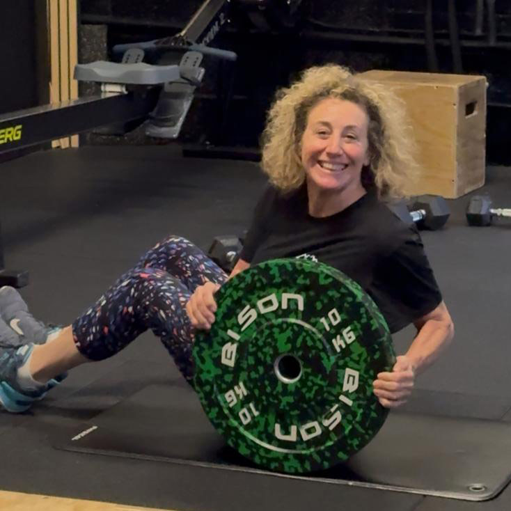 Woman holding a weight plate during training at the PT Club studio in Archway